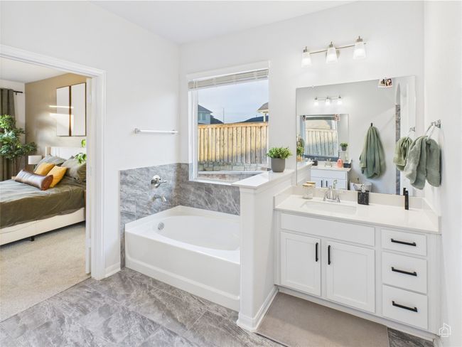 Ensuite bathroom featuring a bath, vanity, and baseboards | Image 24