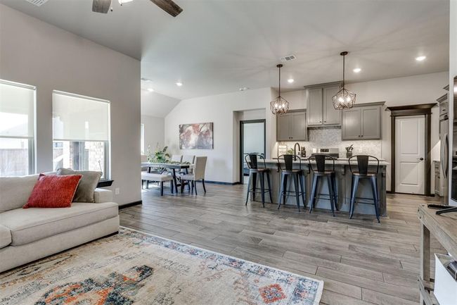 Living room with recessed lighting, light wood finished floors, lofted ceiling, and a ceiling fan | Image 39