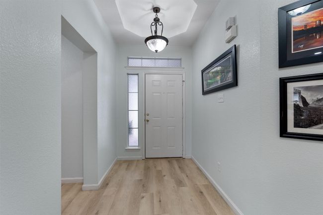 Entryway with light wood-style flooring, natural light abounds, and a tray ceiling | Image 4