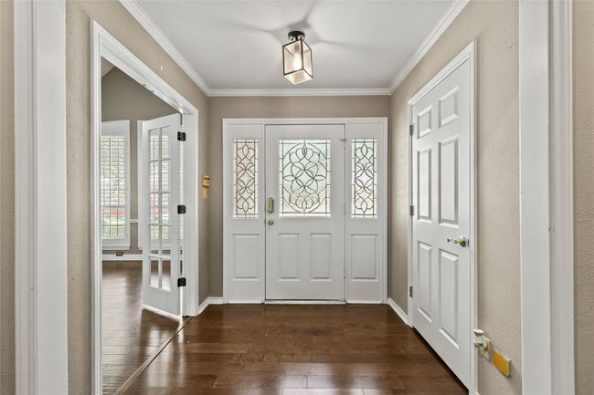 Entryway with dark wood finished floors and crown molding | Image 7