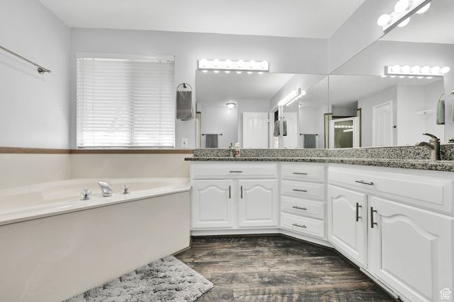 Bathroom with vanity, an enclosed shower, a garden tub, and wood finished floors | Image 19