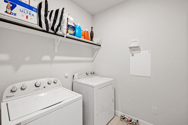 Laundry area featuring washer and clothes dryer, baseboards, and laundry area | Image 16