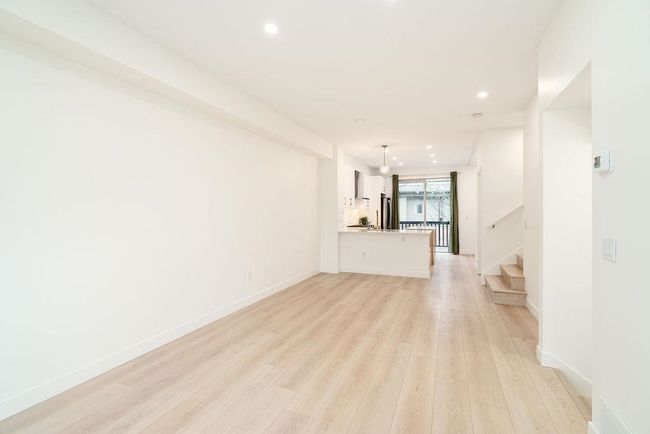 Unfurnished living room with baseboards, recessed lighting, light wood-style flooring, and stairway | Image 16