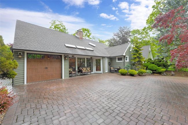 View of front of home featuring an attached garage, a chimney, roof with shingles, and driveway | Image 4