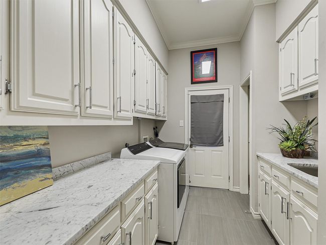 Laundry room featuring cabinet space, independent washer and dryer, and crown molding | Image 31