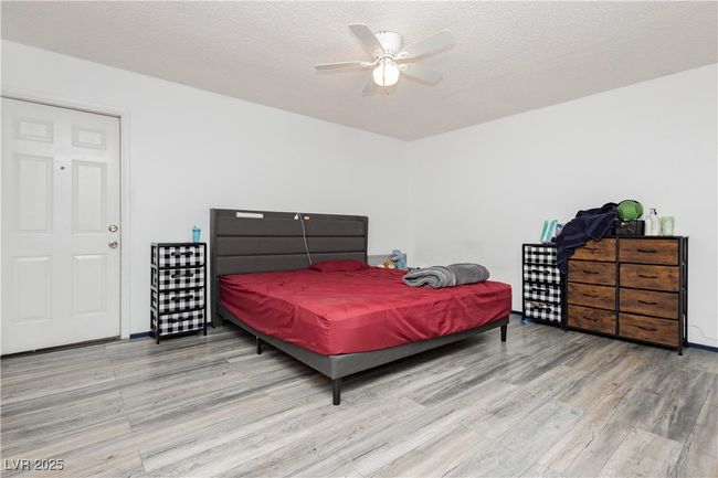 Bedroom with wood finished floors, a textured ceiling, and a ceiling fan | Image 10