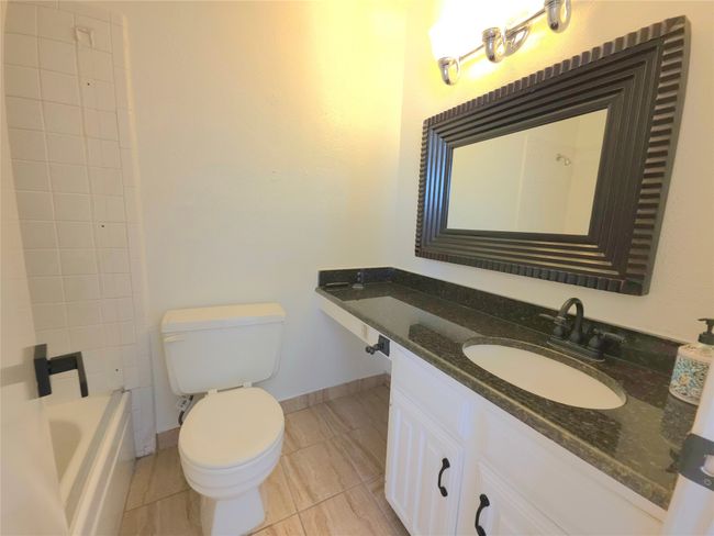 Full bathroom with vanity, tile patterned floors, and shower / bathtub combination | Image 16