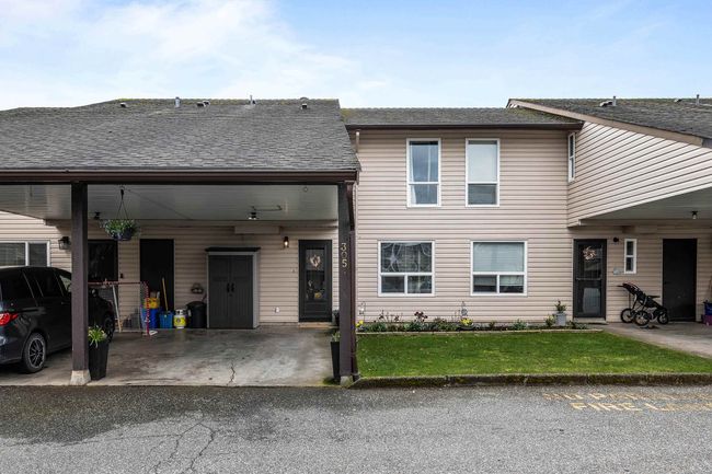 Townhome / multi-family property with a front yard and roof with shingles | Image 27