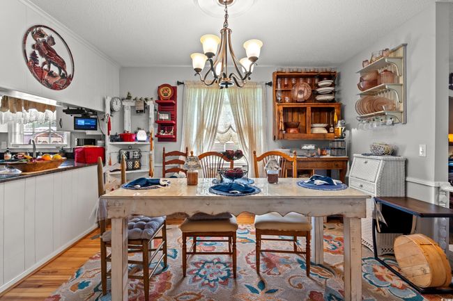 Dining room with light wood-type flooring, a chandelier, and a textured ceiling | Image 6