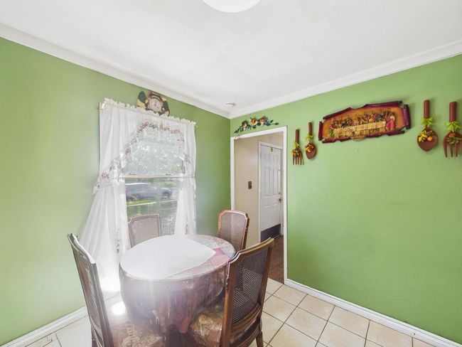 Dining area with light tile patterned floors and baseboards | Image 12