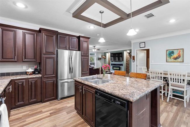 Ample space in the kitchen to move about, cabinets flanking both sides of the refrigerator for additional storage | Image 13