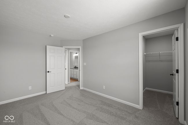 unfurnished bedroom featuring a walk in closet, carpet, and baseboards | Image 19