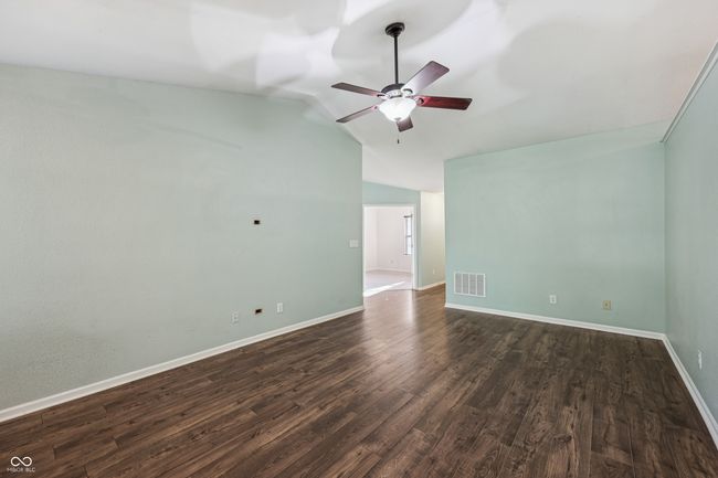 spare room with ceiling fan, lofted ceiling, and dark wood finished floors | Image 7