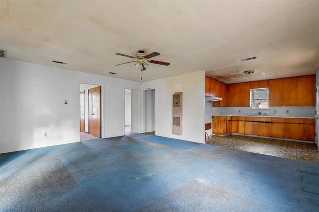Unfurnished living room with ceiling fan and dark colored carpet | Image 11