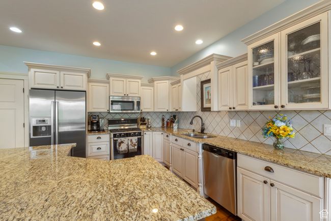 Kitchen with stainless steel appliances, a sink, cream cabinets, and recessed lighting | Image 14