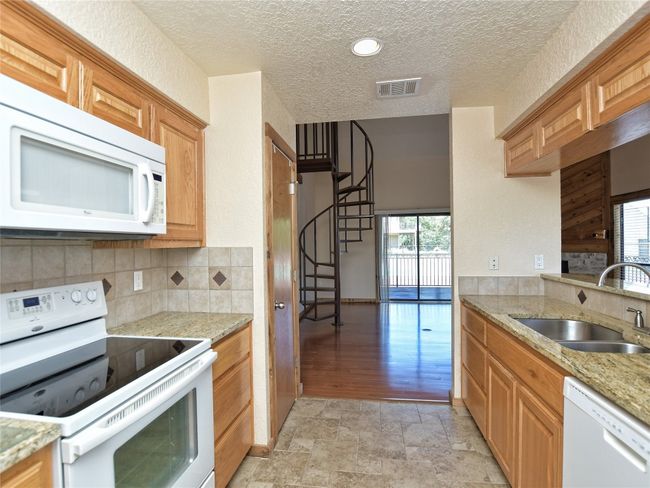Glass top electric range, microwave, dishwasher, disposal, ample cabinets and granite counters are highlights of the Kitchen. | Image 11