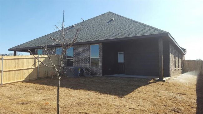 Rear view of property with brick siding, roof with shingles, and central AC unit | Image 13