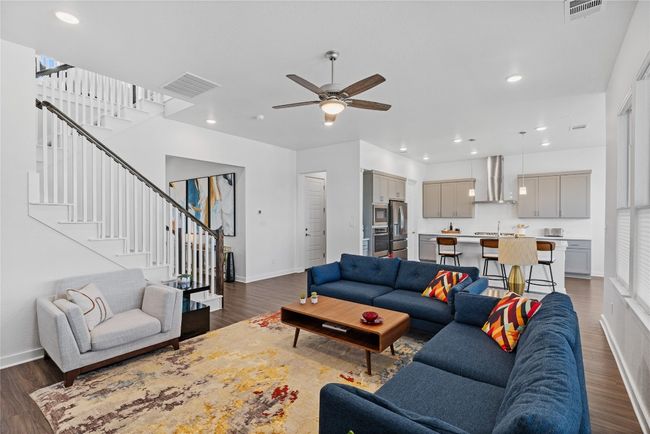 Living room with wood finished floors, stairway, and visible vents | Image 10