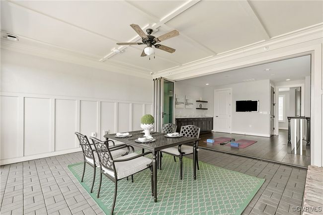 Dining area with ceiling fan, brick floor, visible vents, and a decorative wall | Image 32