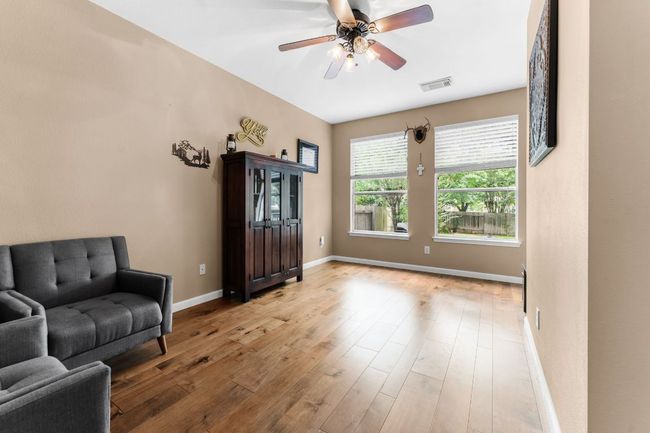 Living area with baseboards, a ceiling fan, and wood finished floors | Image 16