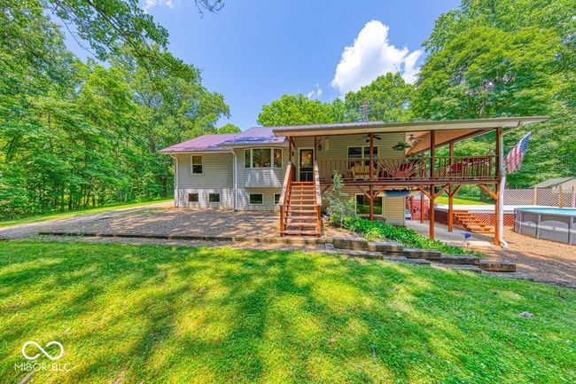 back of property with stairway, a ceiling fan, a lawn, and a deck | Image 58
