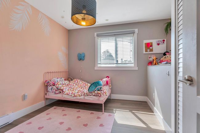 Bedroom featuring wood finished floors, baseboard heating, and baseboards | Image 24