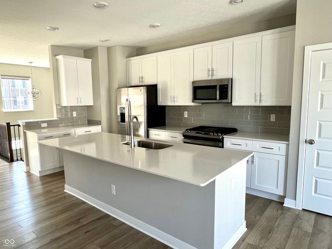 Gourmet chef's kitchen with SS appliances, gas range, Shelf Genie cabinet system, quartz countertops. | Image 19