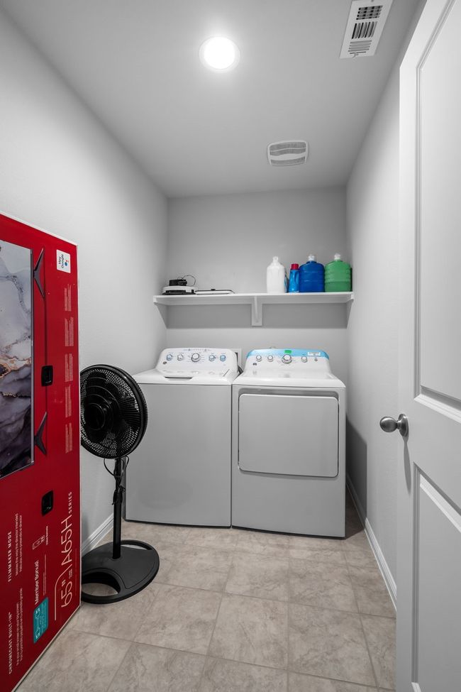Clothes washing area featuring baseboards, washing machine and dryer, visible vents, and laundry area | Image 22