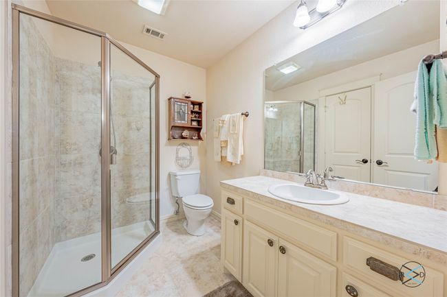 Bathroom featuring tile flooring, oversized vanity, toilet, and walk in shower | Image 19