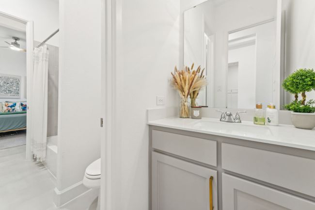 Bathroom featuring vanity, toilet, and shower / bath combination with curtain | Image 29