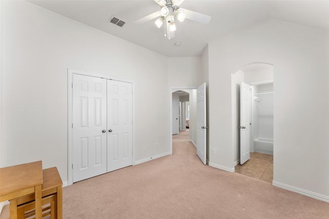 Unfurnished bedroom with arched walkways, light carpet, a closet, lofted ceiling, and a ceiling fan | Image 26