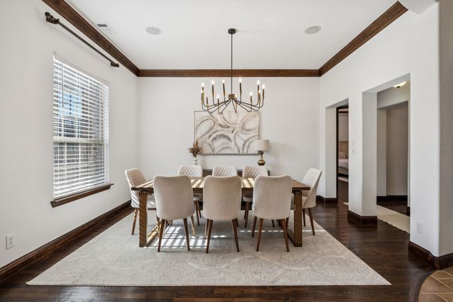 Dining space with ornamental molding, a chandelier, and wood finished floors | Image 23