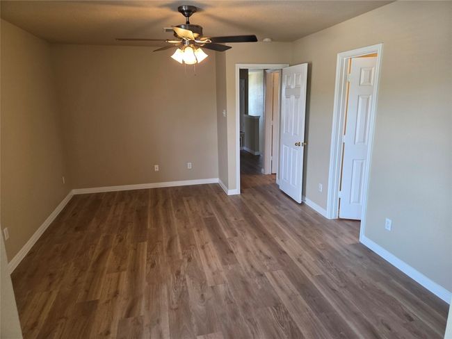 Unfurnished room featuring ceiling fan and dark wood-type flooring | Image 28