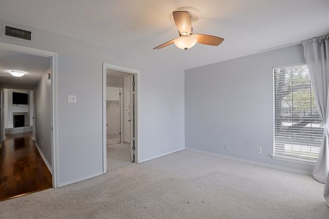 Unfurnished bedroom featuring visible vents, baseboards, carpet flooring, and a fireplace with raised hearth | Image 13