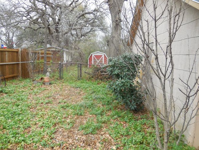 View of yard with a storage shed, fence, and an outdoor structure | Image 13