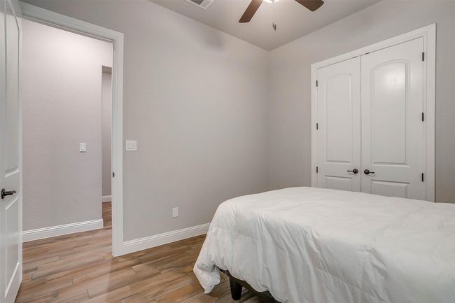 Bedroom with wood finished floors, a closet, and a ceiling fan | Image 22