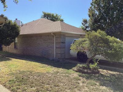 View of property exterior featuring a garage and a yard | Image 2