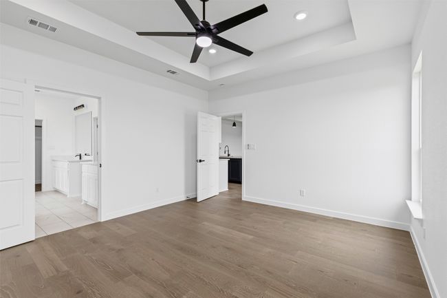 Unfurnished bedroom featuring visible vents, recessed lighting, wood finished floors, and a tray ceiling | Image 28
