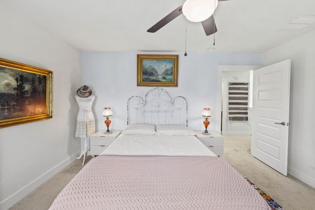 Bedroom featuring baseboards, visible vents, and light colored carpet | Image 19