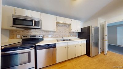 Kitchen featuring sink, appliances with stainless steel finishes, tasteful backsplash, and light hardwood / wood-style floors | Image 3