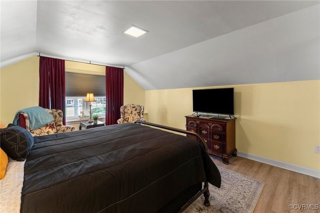 Bedroom featuring vaulted ceiling, baseboards, and wood finished floors | Image 21