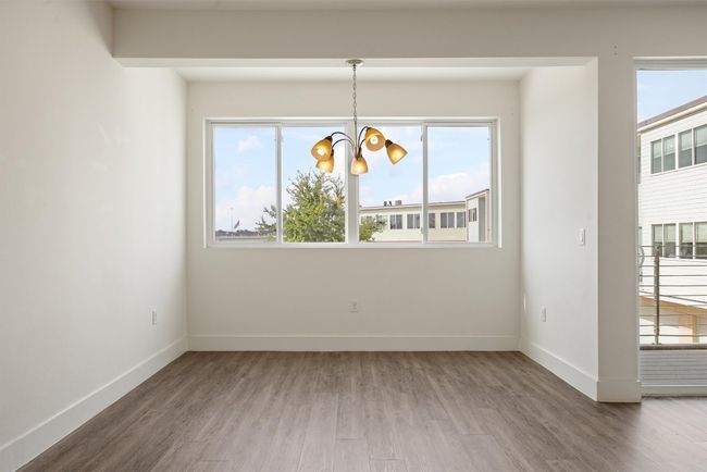 Unfurnished dining area featuring plenty of natural light, a chandelier, and wood finished floors | Image 6
