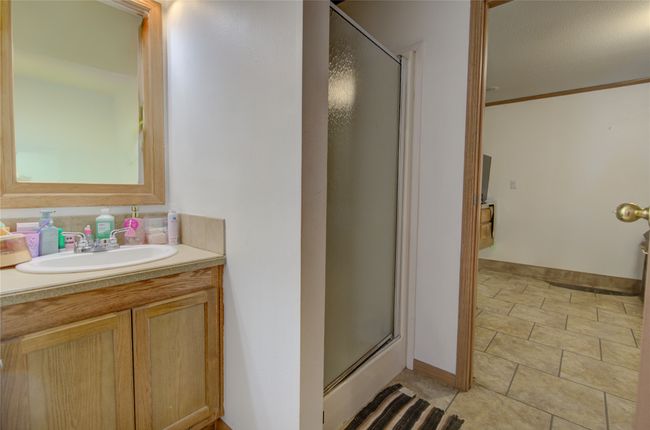 Bathroom with a shower with door, crown molding, tile patterned floors, and vanity | Image 6