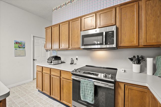 Kitchen featuring stainless steel appliances, brown cabinets, and light countertops | Image 20