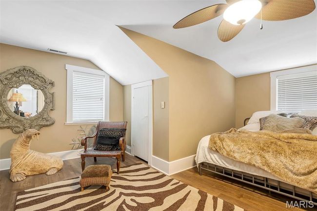Bedroom with vaulted ceiling, wood finished floors, and a ceiling fan | Image 71