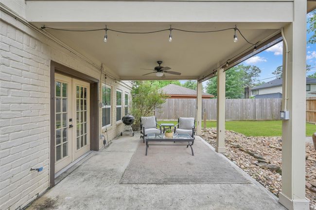 Exit the French Doors off the Living Room to relax under a covered patio with ceiling fan with light and additional string lights the seller is leaving. Shades also help keep out the sun when you prefer a little break. | Image 25