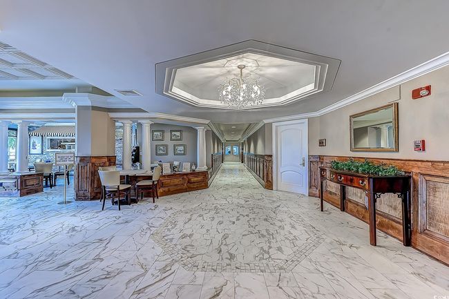 Interior space with ornamental molding, ornate columns, an inviting chandelier, and a tray ceiling | Image 30
