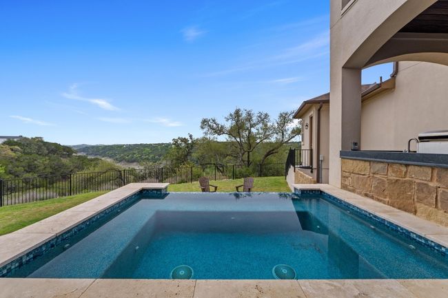 View of swimming pool with a lawn, a fenced backyard, a fenced in pool, and a jacuzzi | Image 38