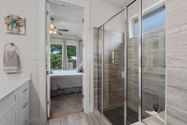 Ensuite bathroom with a ceiling fan, a stall shower, vanity, and wood finished floors | Image 19
