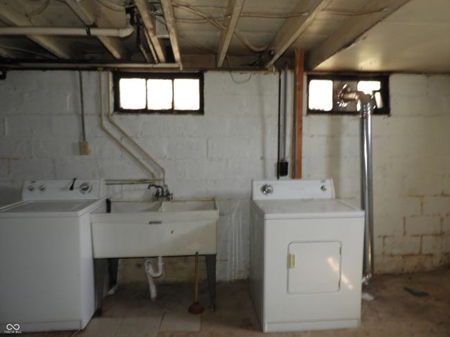 laundry room in basement with a sink, washer and clothes dryer, and laundry area | Image 12